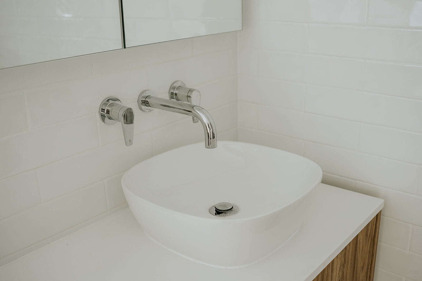 White basin with satin chrome tapware and mirror cabinet